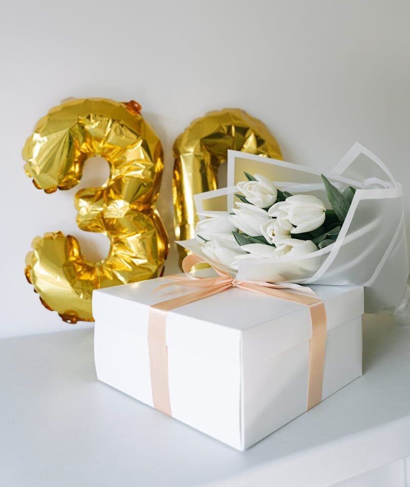 30th birthday celebration with balloons, tulip bouquet, and gift box.